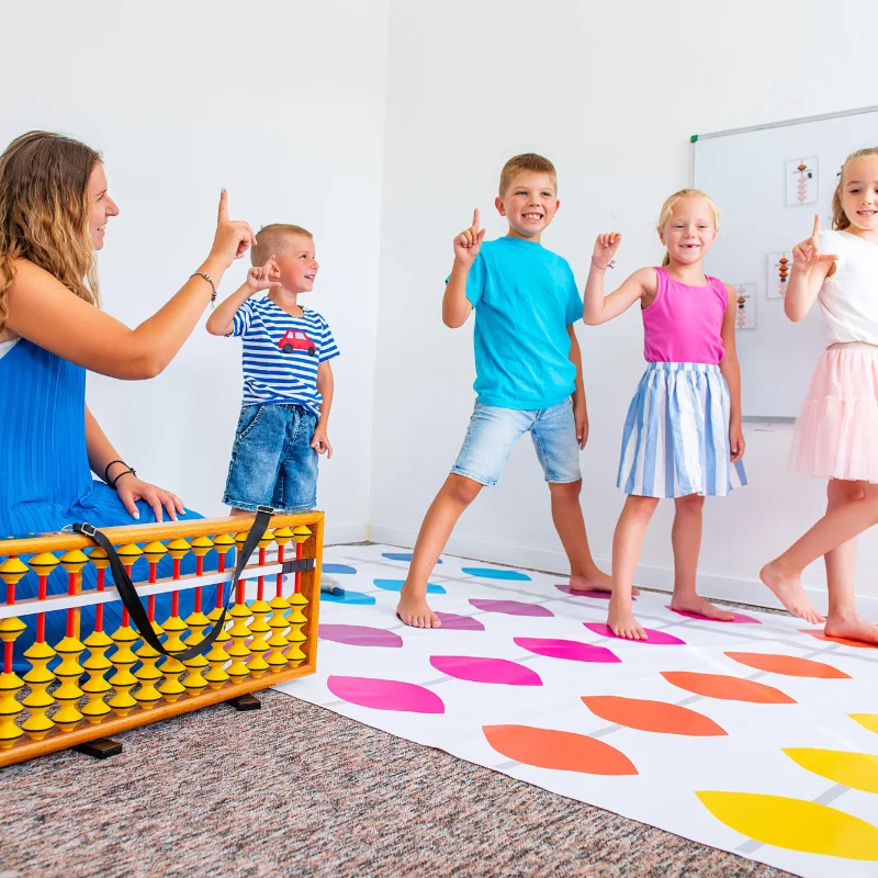 چهار کودک بیش‌فعال با مربی خود در حال انجام بازی حرکتی روی زمین