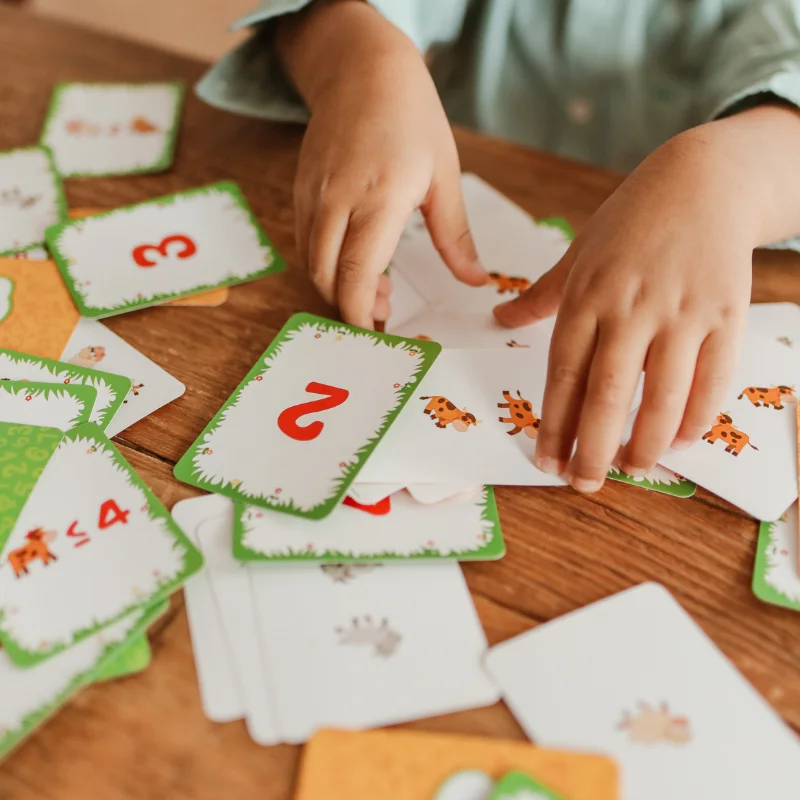 آموزش مفاهیم ریاضی با کارتهای بازی برای کودکان دارای اختلال ریاضی کودک در حال بازی با کارتهای عدد و تعداد برای یادگیری مفاهیم ریاضی