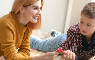 مادری که با عشق و صبر در حال یاد دادن حروف الفبا به کودک دارای اختلالات یادگیری است