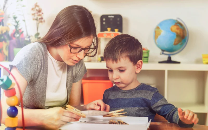  مادری که با صبر و دقت، مهارت‌های حرکتی ظریف را به کودک پسر خود آموزش می‌دهد