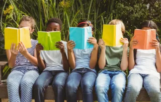 چند کودک در حال خواندن کتاب برای نمایش اهمیت آموزش در اختلال خواندن