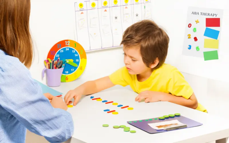 مربی در حال کار با کودک اوتیسم با روش ABA، روشی مؤثر برای یادگیری ساختاریافته اوتیسم.