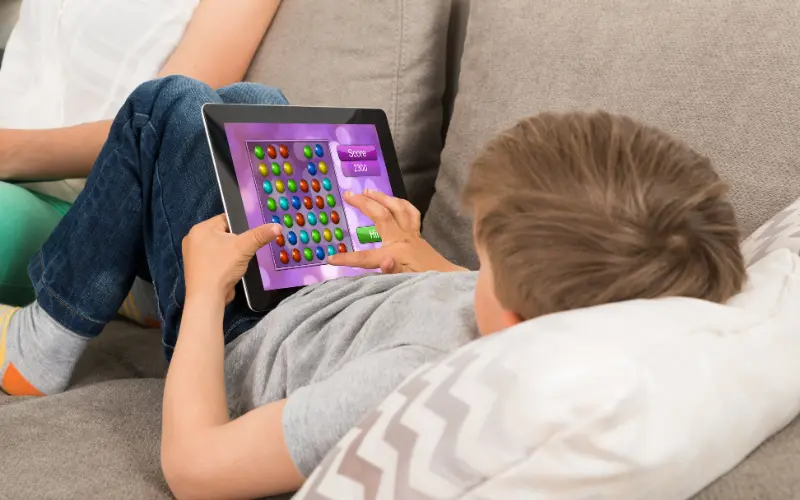 کودکی که با تبلت بازی شناخت رنگ‌ها انجام می‌دهد، روش مبتنی بر فناوری برای یادگیری کودکان اتیسم.