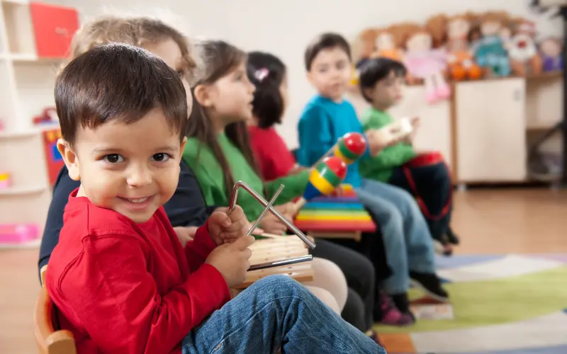 چند کودک با آلات موسیقی کودکانه می‌نوازند، روش موسیقی‌درمانی برای یادگیری کودکان اتیسم.