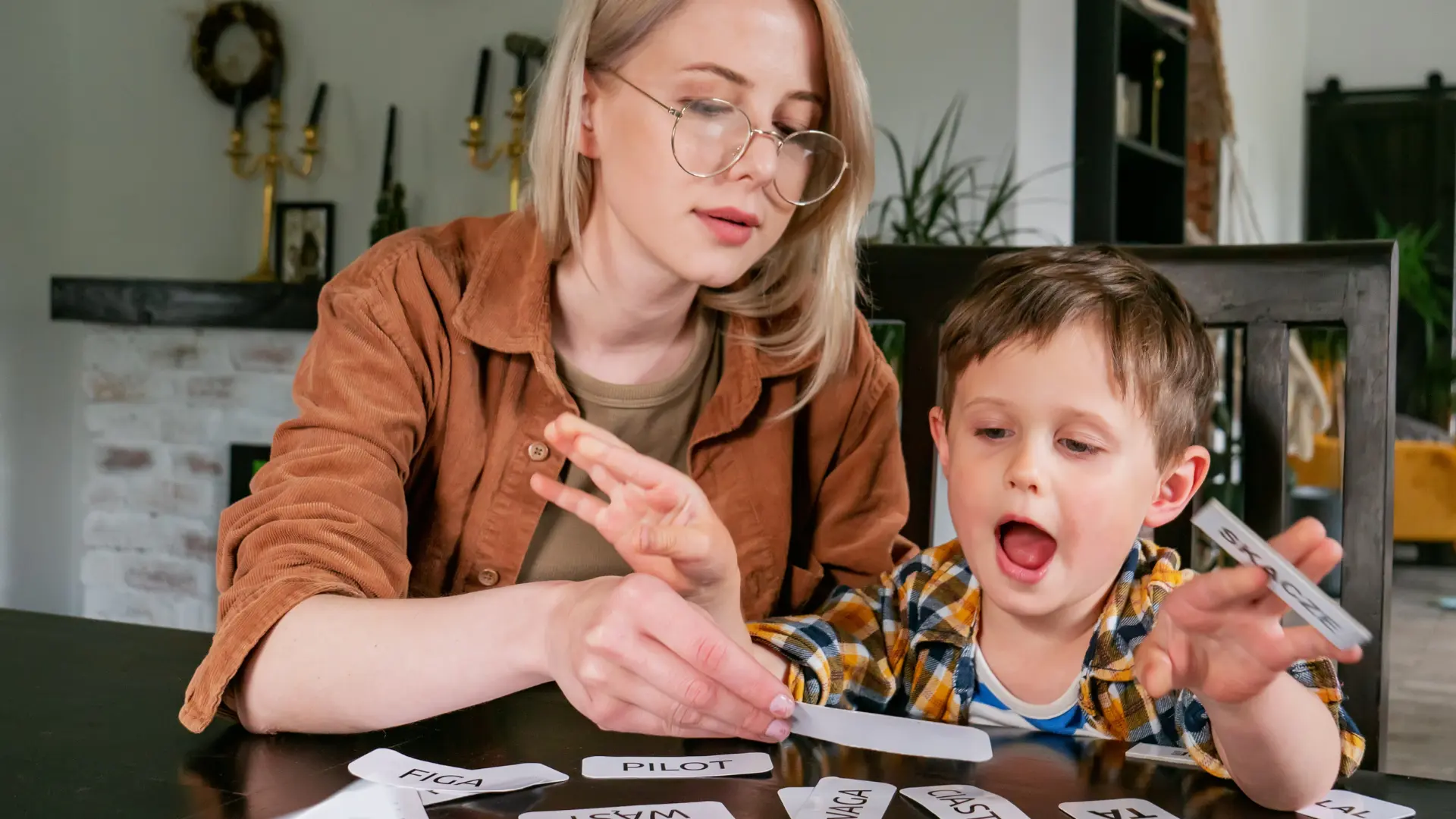 مادری که به کودک اوتیسم خود با کارت‌های حروف آموزش می‌دهد، نشان‌دهنده روش‌های آموزشی اوتیسم است.